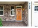 Inviting covered front porch with stone accents, warm lighting, and tiled flooring at 532 Front Ridge Dr, Cary, NC 27519