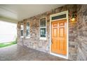 Inviting covered front porch with stone accents, warm lighting, and tiled flooring at 532 Front Ridge Dr, Cary, NC 27519