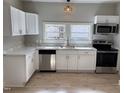 Bright kitchen with white cabinets, stainless steel appliances, and a view out the double window at 630 North Ave, Burlington, NC 27217