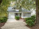 Well-maintained home with gray siding, brick accents, attached garage, and mature landscaping at 10 Marchmont Ct, Durham, NC 27705