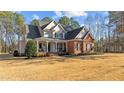 Elegant two-story house showcasing a spacious front yard with mature trees at 1328 Wakefield Farm Rd, Zebulon, NC 27597