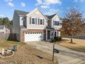 Two-story home featuring an attached two car garage, manicured lawn, and mature tree at 1510 Roaring Rapids Rd, Raleigh, NC 27610
