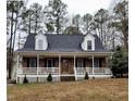 Inviting brick home with a spacious front porch, perfect for relaxing and enjoying the serene, wooded surroundings at 266 Sagamore Dr, Louisburg, NC 27549