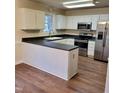Bright kitchen featuring a breakfast bar, stainless appliances and wood-look vinyl floors at 266 Sagamore Dr, Louisburg, NC 27549
