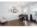 Cozy living room featuring hardwood floors, piano, chandelier, and natural light at 280 Scotland Dr, Youngsville, NC 27596