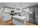 Modern kitchen with stainless steel appliances, marble counters, and central island at 2908 Woods Pl, Raleigh, NC 27607