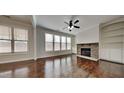 Bright living room featuring hardwood floors, large windows, a stone fireplace, and built-in shelving at 300 Nelson Ln, Clayton, NC 27527