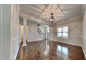 Spacious living room with beautiful hardwood floors, coffered ceilings, and modern lighting fixtures at 300 Nelson Ln, Clayton, NC 27527