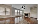 Bright living room featuring hardwood floors, large windows, a stone fireplace, and built-in shelving at 300 Nelson Ln, Clayton, NC 27527