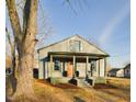 Inviting home exterior with a cozy front porch and mature trees, enhancing curb appeal at 301 W Hill S Ave, Hillsborough, NC 27278