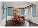 Elegant dining room with hardwood floors, chandelier, and a large china cabinet at 303 Shakespeare St, Morrisville, NC 27560
