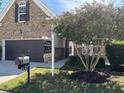 Beautiful stone-front home with a well-manicured lawn and a mature flowering tree in the yard at 3108 Fortress Gate Dr, Raleigh, NC 27614
