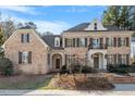 Two-story brick home showcasing classic architecture with a black trimmed balcony and well-manicured lawn at 3605 Camp Mangum Wynd, Raleigh, NC 27612