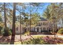 Brick home exterior framed by mature trees, highlighting a well-maintained lawn and classic design at 3605 Camp Mangum Wynd, Raleigh, NC 27612