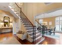 Grand foyer featuring hardwood floors, staircase with iron railings, and elegant chandelier in adjacent dining area at 3605 Camp Mangum Wynd, Raleigh, NC 27612