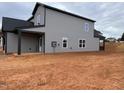 Side view of the two-story home with gray siding, black trim, and a covered porch area at 4309 Darius Ln # 26, Fuquay Varina, NC 27526