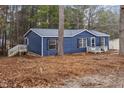 Side view of this lovely blue home, showcasing the entrance with wood stairs and black shutters at 453 Deer Vw, Sanford, NC 27332