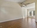 Sunlit living room featuring wood floors, a modern ceiling fan, and large windows at 4709 Wyndchase Ct, Fuquay Varina, NC 27526