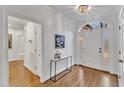 Bright foyer with hardwood floors, arched doorway, and elegant decor at 4800 Salem Ridge Rd, Holly Springs, NC 27540