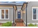 Inviting front entryway featuring a wreath on the door and brick steps at 4800 Salem Ridge Rd, Holly Springs, NC 27540