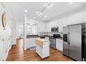 Bright kitchen with white cabinets, stainless steel appliances, and hardwood floors at 5117 Singing Wind Dr, Raleigh, NC 27612