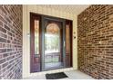 Close-up of the front door featuring decorative glass panels and a brick facade at 6025 Spring Valley Dr, Raleigh, NC 27616