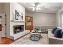 Cozy living room featuring a brick fireplace, wood floors, and neutral-toned furnishings at 6025 Spring Valley Dr, Raleigh, NC 27616