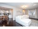 Bright living room with hardwood floors, modern lighting, and a comfortable white sofa at 609 S Allen Rd, Wake Forest, NC 27587