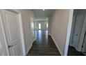 Inviting hallway with hardwood flooring, neutral paint, and doors leading to various rooms at 622 Ravensworth Dr, Garner, NC 27529