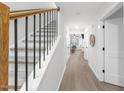 Bright hallway with wood floors, white walls, and a staircase with black railings at 628 Bragg St, Raleigh, NC 27610