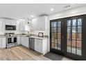 Bright kitchen features white cabinets, stainless steel appliances, and glass doors at 6309 Cape Charles Dr, Raleigh, NC 27617