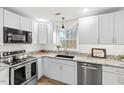 Well-lit kitchen features stainless steel appliances, granite countertops, and white cabinets at 6309 Cape Charles Dr, Raleigh, NC 27617