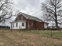 Side and back of brick home with a metal roof and a small wooden deck at 7913 Sylvan Rd, Liberty, NC 27298