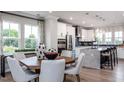 Eat-in kitchen featuring white cabinetry, stainless steel appliances, large windows and a speckled island with bar stool seating at 810 Hyperion Aly, Wake Forest, NC 27587