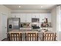 Bright, open kitchen featuring white cabinets, granite countertops, and stainless steel appliances at 86 Saddle Mare St, Clayton, NC 27520