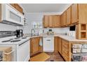 Functional kitchen features white appliances, wood cabinets, and ample counter space at 104 Piquot Drive, Louisburg, NC 27549