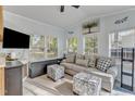 Bright living room with neutral walls, a grey sofa, and many windows with wooded views at 104 Piquot Drive, Louisburg, NC 27549
