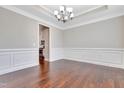 Elegant dining room with hardwood floors, wainscoting, decorative trim, and a chandelier at 1109 Hemby Ridge Ln, Morrisville, NC 27560