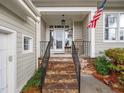 Inviting front porch with stone steps and decorative wrought iron railings at 1301 Groves Field Ln, Wake Forest, NC 27587