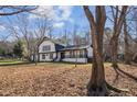 Two-story home with striking black-and-white contrast, complemented by the natural beauty of the surrounding trees at 14115 Allison Dr, Raleigh, NC 27615