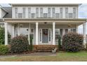 Inviting front porch with columns, decorative plants, and a wreath on the gray front door at 177 Clarence Ln, Garner, NC 27529