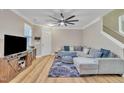 Bright living room featuring hardwood floors, a plush sofa, and a large television at 181 Steam Engine Way, Garner, NC 27529