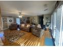Cozy living room featuring hardwood floors, natural light, comfortable seating, and a ceiling fan at 2113 Nc 55, Coats, NC 27521