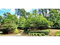 Lush front yard with mature trees and manicured landscaping offers a serene and private setting at 216 Copper Beech Ct, Chapel Hill, NC 27517