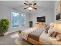 Cozy bedroom featuring large windows, neutral colors, and a ceiling fan with light fixture at 2836 Thurrock Dr, Apex, NC 27539