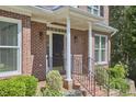 Close up on the front entry, brick facade, small bushes, black door with number, and white pillars at 407 Crickentree Dr, Cary, NC 27518