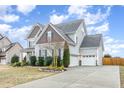 Lovely two-story home with a two-car garage, well-maintained lawn, and charming landscaping at 58 Atkins Village Ct, Fuquay Varina, NC 27526