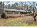 Attractive brick house with a covered porch and mature trees in the yard at 628 Stratford Dr, Zebulon, NC 27597