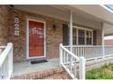 Close-up of the front porch, showing the red front door and white railings at 628 Stratford Dr, Zebulon, NC 27597