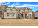 Charming two-story house showcasing a mix of stone and siding exterior, complemented by landscaped beds at 6509 Sunset Manor Dr, Wake Forest, NC 27587